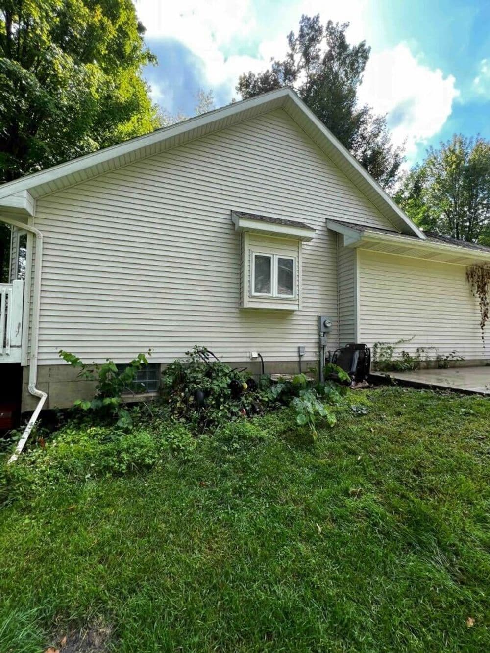 Side view of a modern home with clean siding and a well-maintained lawn.