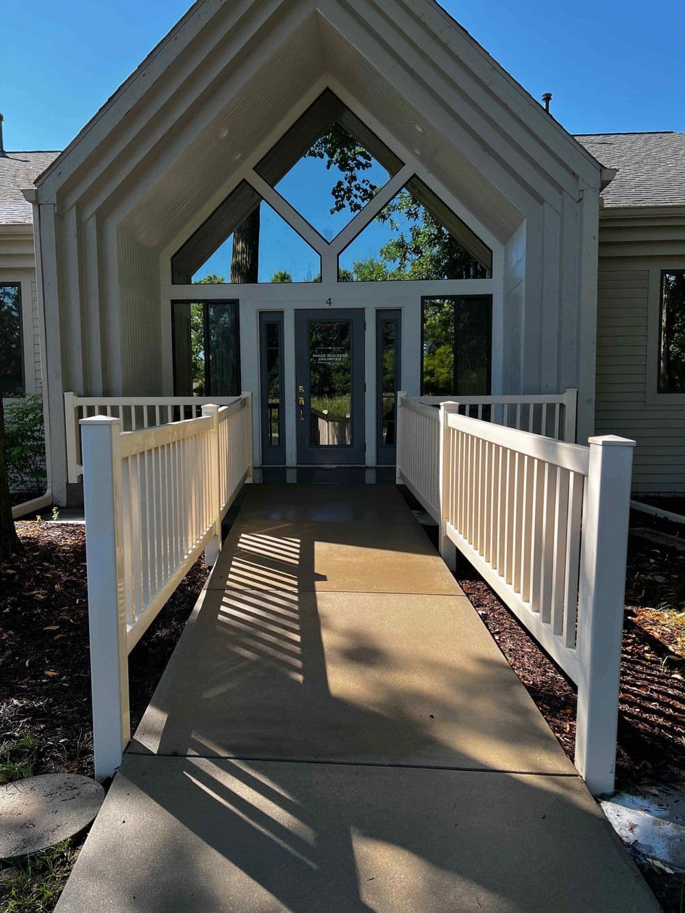 Modern building entrance with a distinctive A-frame design and accessible walkway.