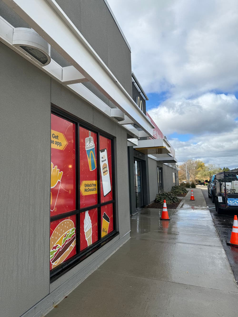 McDonald's exterior with promotional window graphics and cloudy sky.